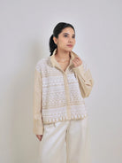 Woman wearing a cream and white patterned shirt by Studio Tui against a plain background