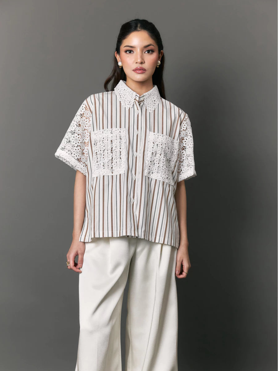 Woman wearing a striped shirt with lace details by Studio Tui against a gray background