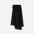 Asymmetrical black pleated skirt by Rashawl for women, featuring a flowy silhouette with a mix of solid and pleated panels, designed with an elastic waistband and drawstring detail.