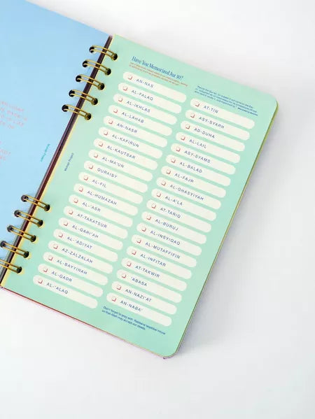 Open planner with a mint green cover on a white background