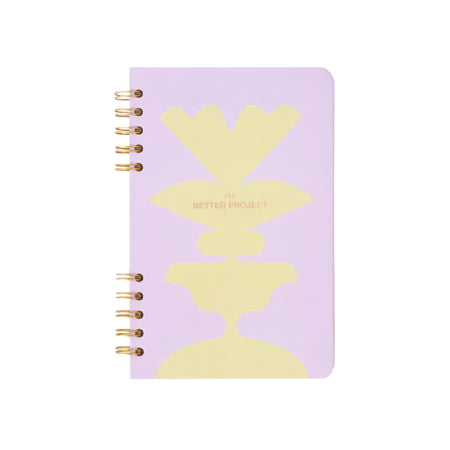 Purple notebook with yellow abstract design from Muhajir Project on a white background
