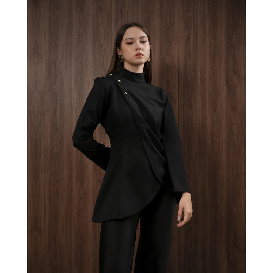 Woman wearing a black blouse by Kasa Heritage against a wooden background