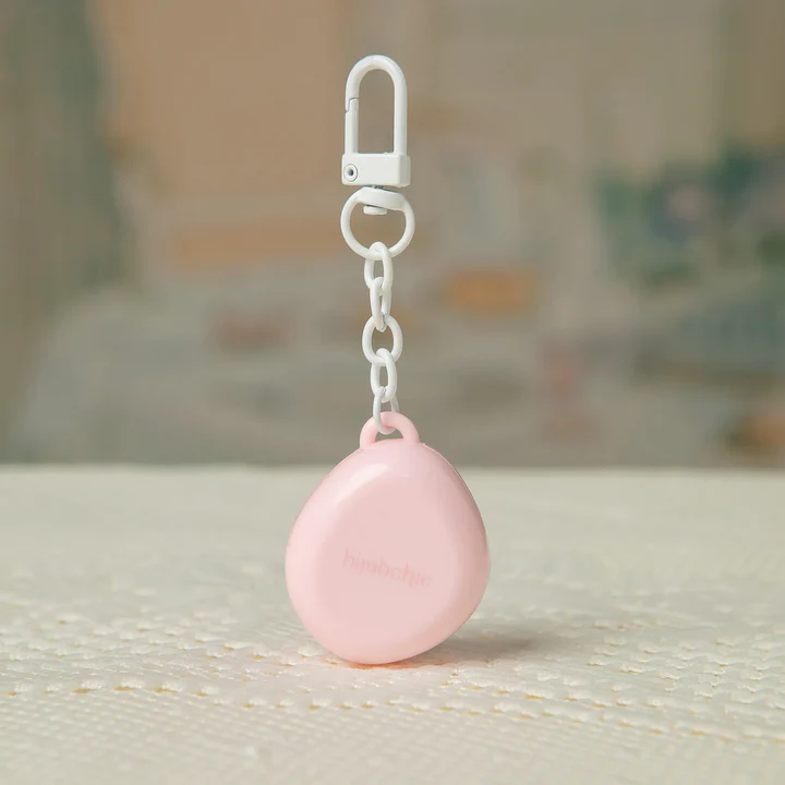 Pink Velvet Moon Solid Perfume packaging by Hijabchic in a keychain with a white clip on a textured surface