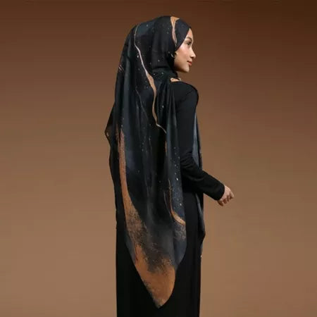 Woman wearing a black hijab with gold accents by Lozy Hijab on a brown background