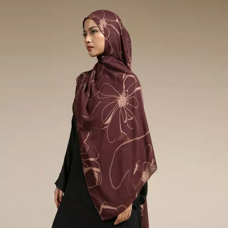 Woman wearing a maroon hijab with floral patterns by Lozy Hijab on a beige background