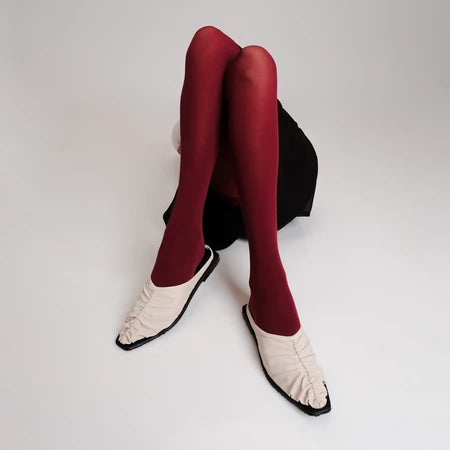 Red tights and ivory Vonee Mules flat shoes by Cekhas on a white background