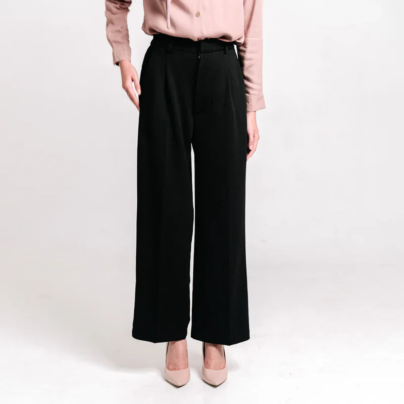 Person wearing a light pink blouse and black wide-leg culotte pants from Atala Scarves on a white background