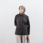 Woman wearing a dark brown shirts from Atala Scarves and beige hijab against a white background