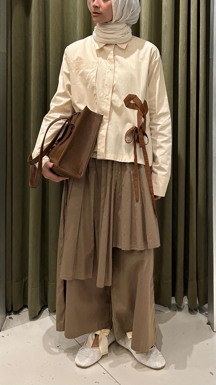 Person wearing a beige top and brown culottes pants by Legan with a hijab against a green curtain background.

Seorang wanita mengenakan atasan berwarna beige dan celana kulot cokelat dari Legan dengan hijab di depan latar belakang tirai hijau.