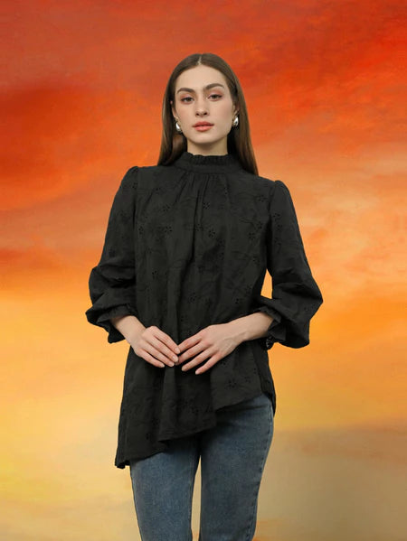 Woman wearing a black blouse by Kasa Heritage with a blurred orange and yellow background