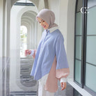 Woman wearing a blue and white striped shirt by Casa Elana with a hijab in an outdoor setting