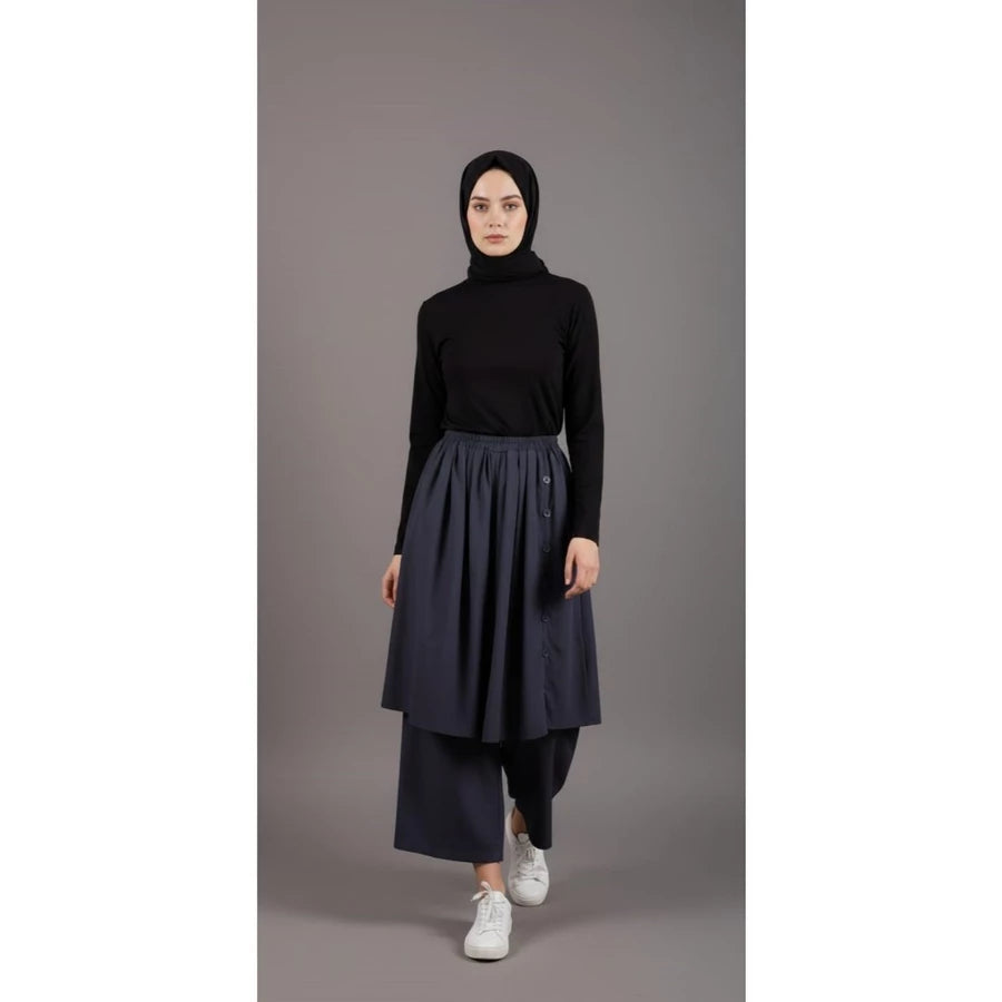 Person wearing a black top and black culottes pants on a gray background.

Seorang wanita mengenakan atasan hitam dan celana kulot hitam di latar belakang abu-abu.