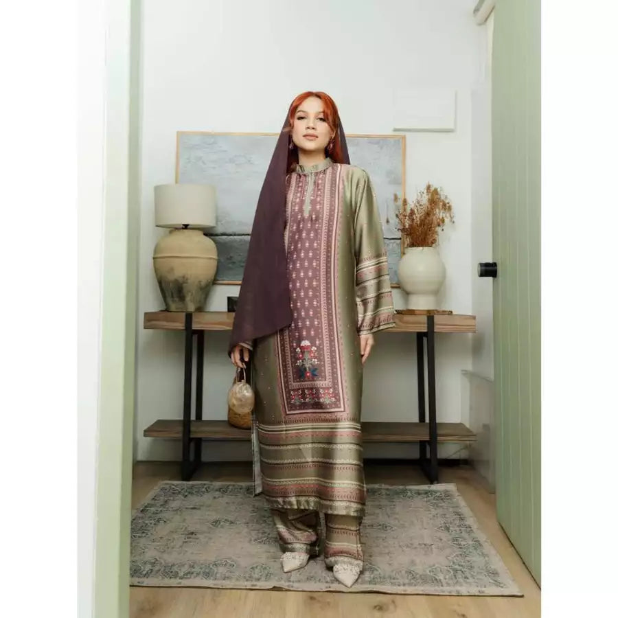 Woman in a matcha color patterned traditional outfit by Haidee Orlin standing in a room with decor elements.