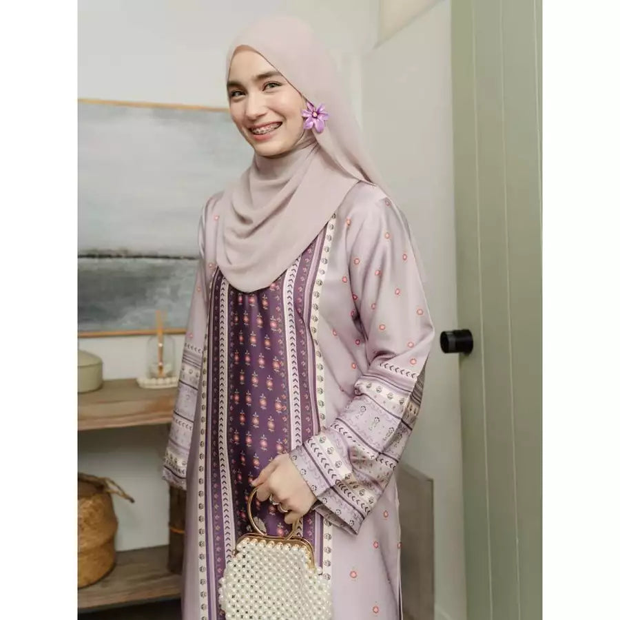 Woman wearing a purple patterned outfit by Haidee Orlin with a hijab in an indoor setting
