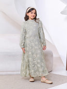 Young girl wearing a light green dress  by Kasa Heritage with floral patterns on a white background