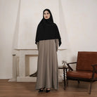 Person wearing a brown abaya by Tubita on a white background