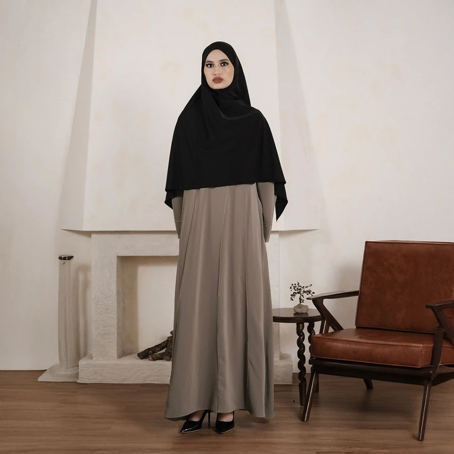 Person wearing a brown abaya by Tubita on a white background