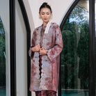 Woman in a traditional outfit by Holy Peony standing in front of a glass door with a blurred outdoor background