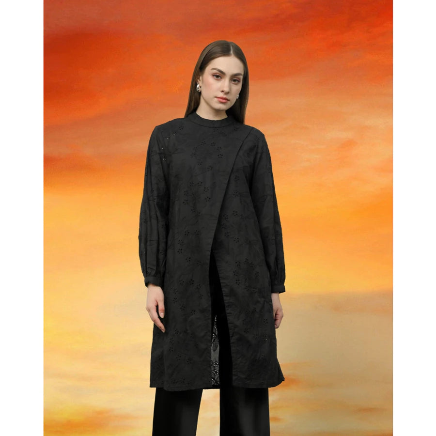 Woman wearing a black tunic by Kasa Heritage against an orange and red abstract background