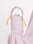 Light purple drawstring bag from Muhajir Project with a label on a white background